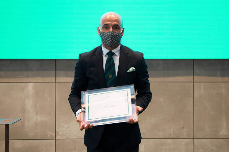 Fotografía de hombre con mascarilla sosteniendo un diploma