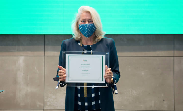 Fotografía de mujer con mascarilla sosteniendo un diploma