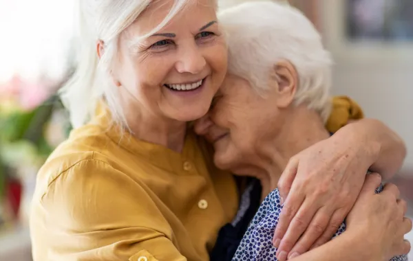 Foto de una señora adulta abrazando a una señora mayor