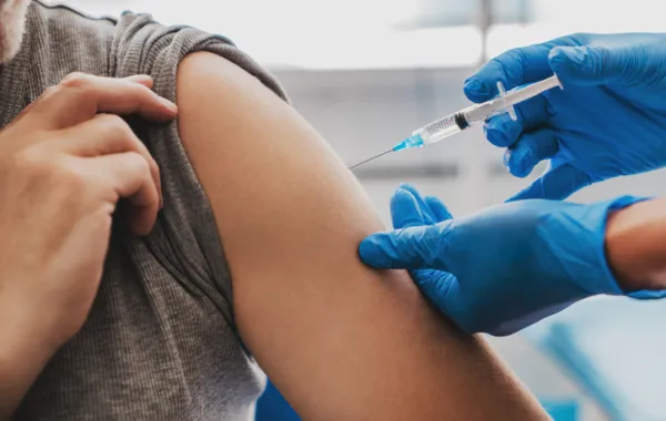 Foto del brazo de una persona que está recibiendo una vacuna