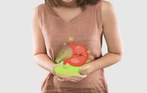 Foto de una mujer que se pone las manos en la zona del estómago para protegerse de las molestias