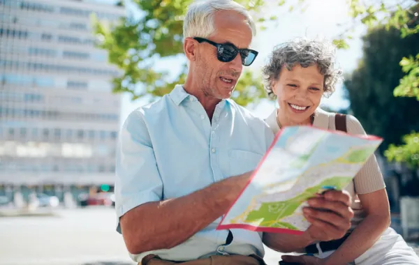 Foto de una pareja de adultos que miran un mapa turistico