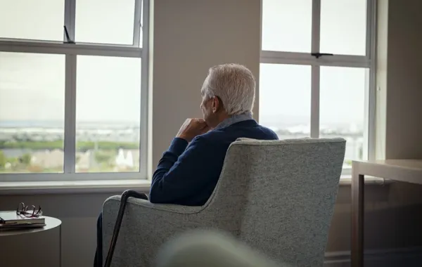 Foto anciano sentado en una butaca, en soledad.