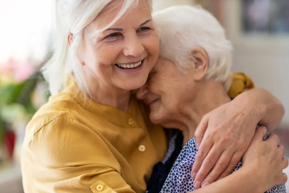 Foto de una señora adulta abrazando a una señora mayor