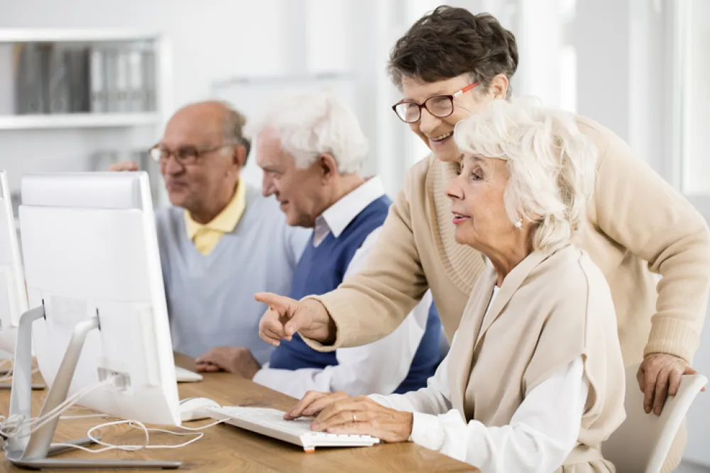 Foto de varias personas mayores aprendiendo a manejar un ordenador