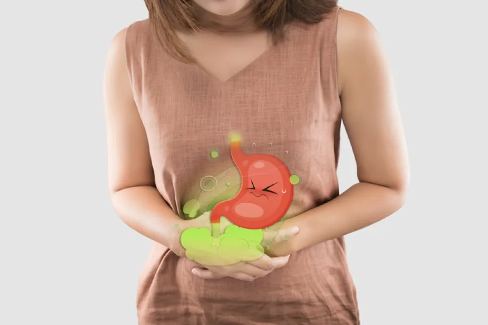 Foto de una mujer que se pone las manos en la zona del estómago para protegerse de las molestias