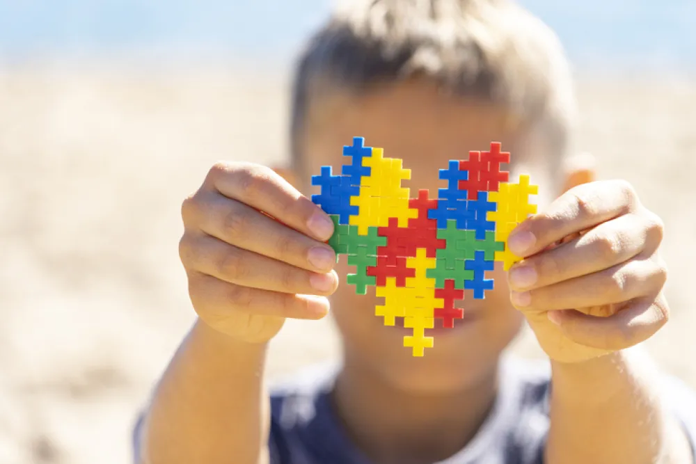 Foto de un niño que sostiene un puzzle con forma de corazón