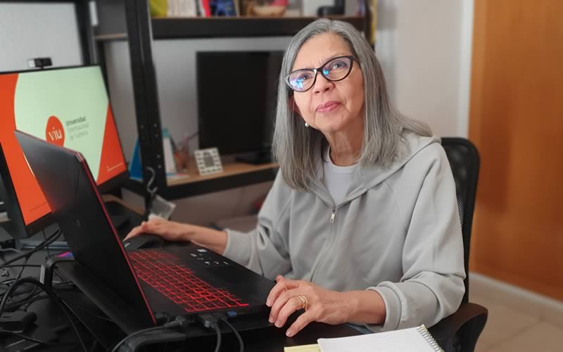 La Doctora Beatriz Valles González sentada delante de su ordenador en su oficina