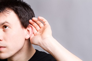 Hombre con su mano en oido escuchando