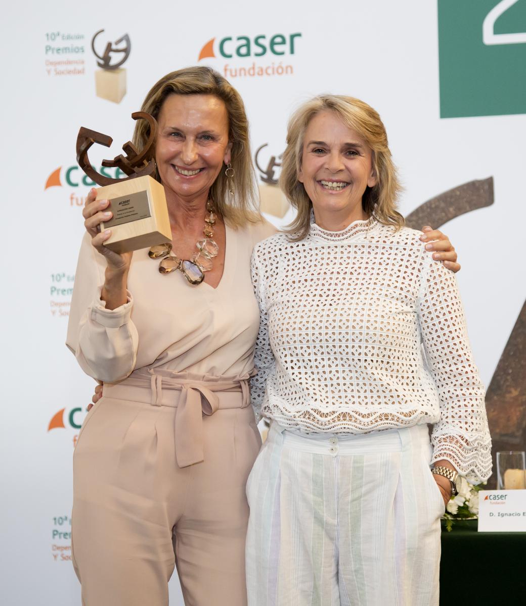 Fotografía de 2 mujeres sosteniendo un trofeo