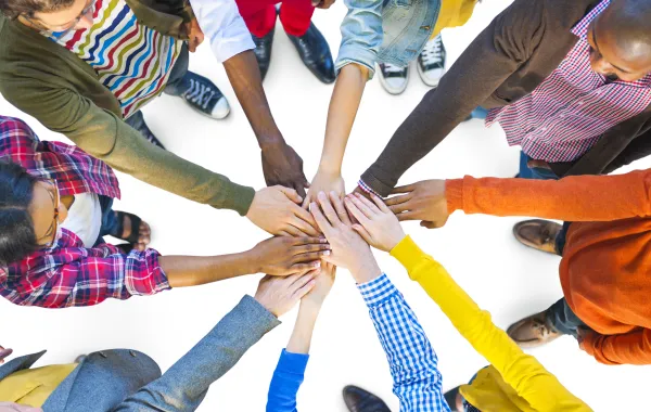 Foto de un grupo de personas juntando las manos