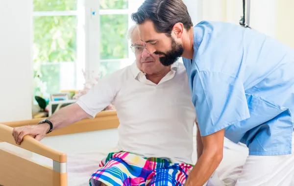 Foto de una persona mayor y otra persona ayundándola