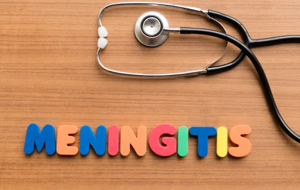 Foto con la palabra meningitis escrita en letras de colores y un estetoscopio