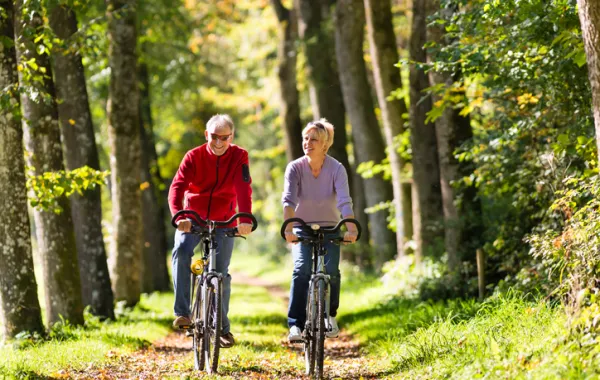 Foto de una pareja montando en bicicleta por un parque