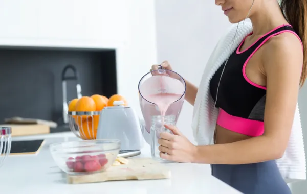Foto de una mujer deportista bebiendo un zumo de frutas