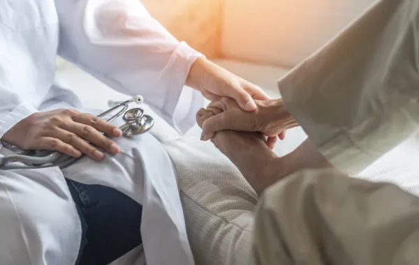 Foto de un medico observando los pies de una persona