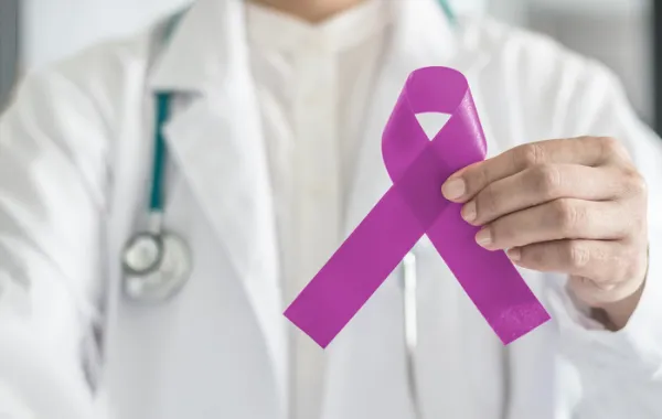 Foto de un médico que sostiene un lazo morado símbolo del día del Alzheimer