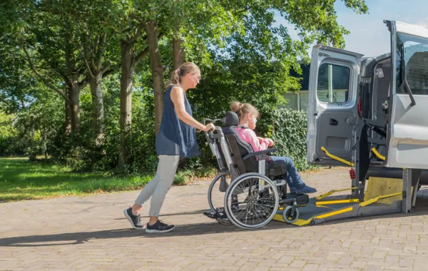 Foto de una mujer que ayuda a subir a una mujer en silla de ruedas a una furgoneta especial