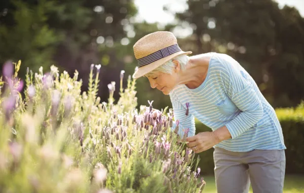 Foto de una mujer en el campo recogiendo flores