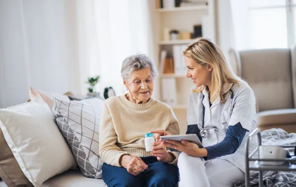 Foto de una mujer mayor acompañada de una medico