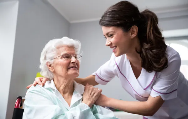Foto de una mujer mayor atendida por una enfermera joven