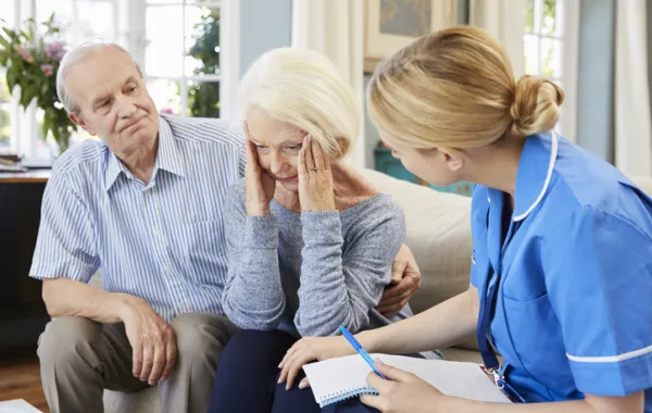 Foto de una pareja mayor acompañada de una enfermera