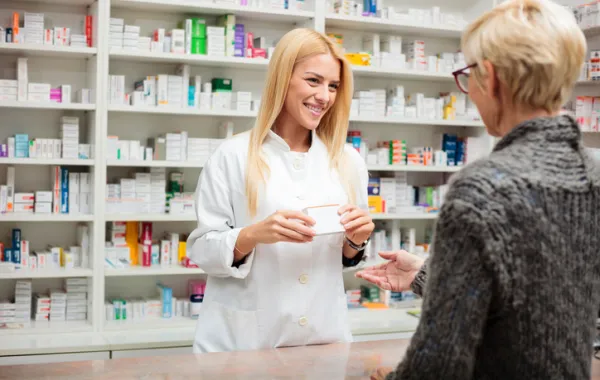 Foto de una mujer farmaceutica que atienda a una señora