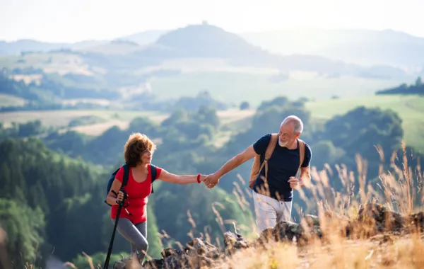 Foto de una pareja de personas adultas caminando por la montaña