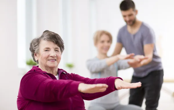 Foto de una mujer mayor haciendo ejercicio junto con un entrenador personal