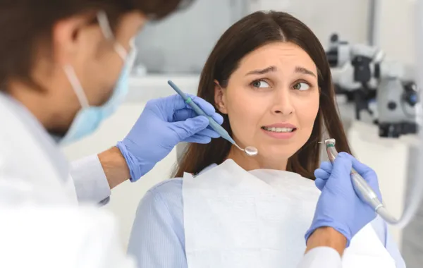 Foto de una persona con cara de miedo en el dentista