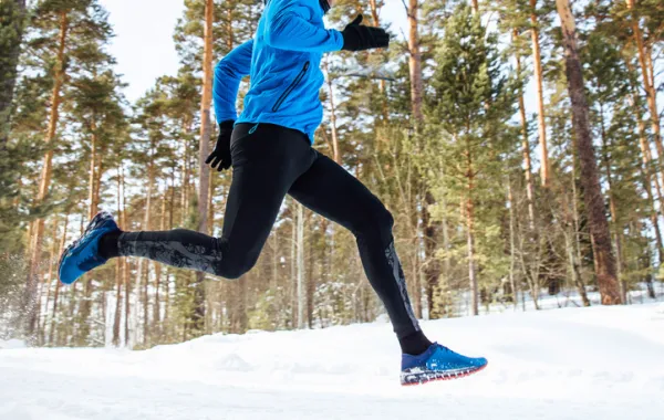 Foto de un deportista corriendo sobre la nieve