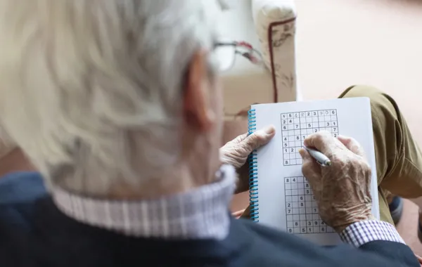 Foto un señor mayor que está haciendo un sudoku