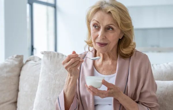 Foto de una señora comiendo un yogur