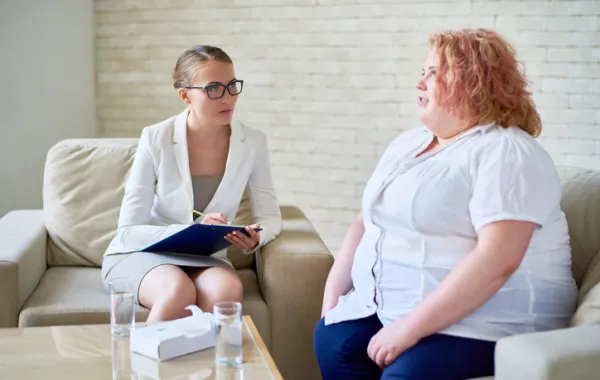 Foto de una mujer obesa hablando con una nutricionista