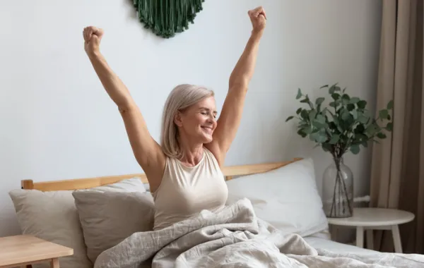 Foto de una mujer despertándose y con cara de felicidad