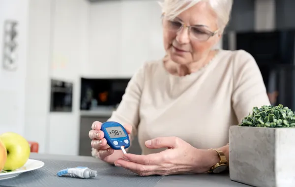 Foto de una mujer mayor midiéndose el azúcar con un aparato específico