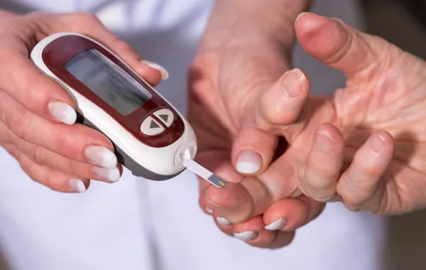 Foto de una mano con un medido de azucar sujetando otra mano