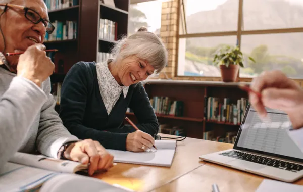 Foto de dos personas maduras estudiando y hablando