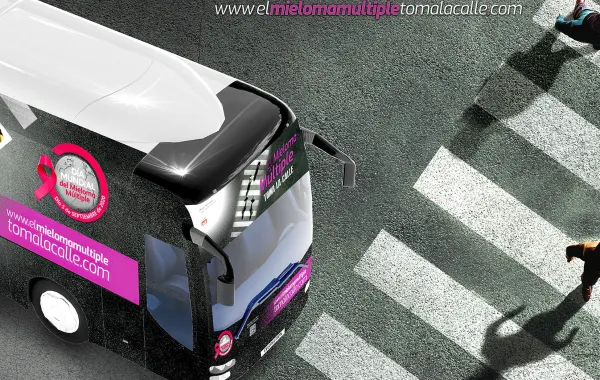 Foto del cartel de la campaña el mieloma toma las calles con un autobus en una calle