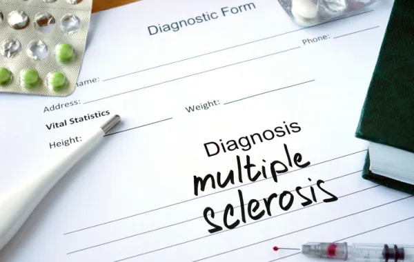 Foto de un informe medico donde aparece escrito a mano diagnostico esclerosis multimple en ingles