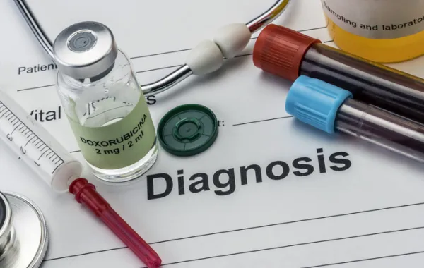 Foto con un papel que pone diagnosis y varias pruebas de sangre