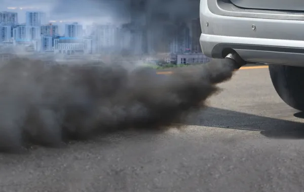 Foto de un coche echando mucho humo por el tubo de escape