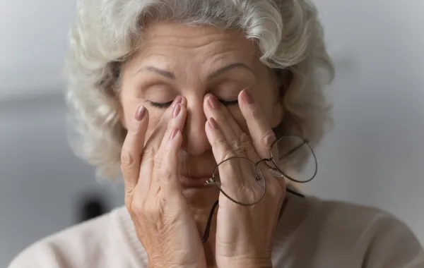 Foto de una mujer mayor tocándose los ojos con las manos en señal de cansanciio