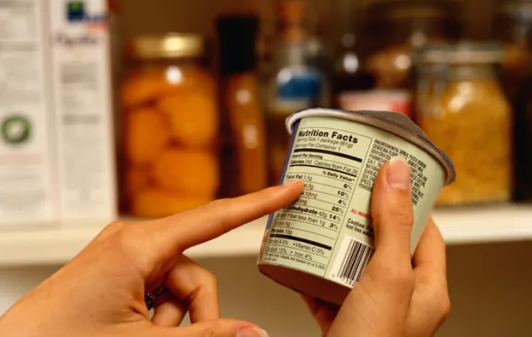 Foto de un dedo que señala el etiquetado de un producto lacteo