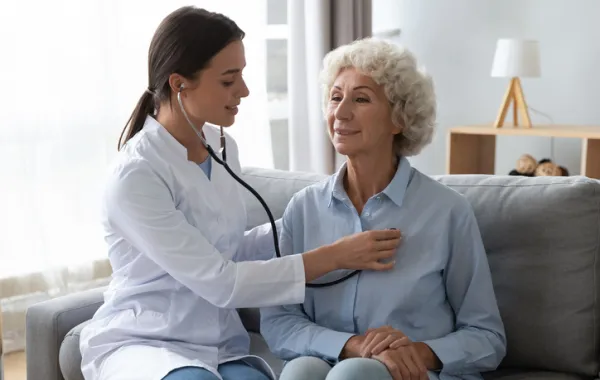 Foto de una doctora oscultando a una señora adulta
