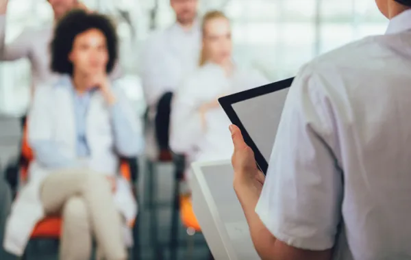 Foto de una mujer que está hablando para un grupo de mujeres profesionales sanitarias