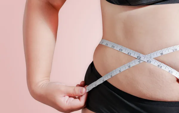 Foto de una persona que se mide la cintura con un metro para calcular la obesidad