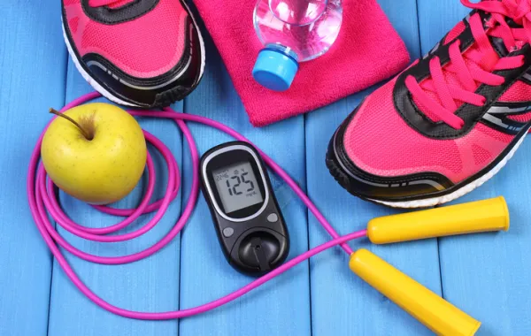 Foto con elementos de ejercicio fisico, manzana y agua