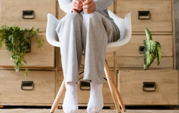 Foto de una piernas sentadas ye de puntillas con una pantalon de gimnasia