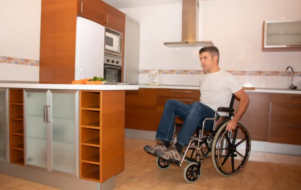 Foto de un señor en silla de ruedas en una cocina
